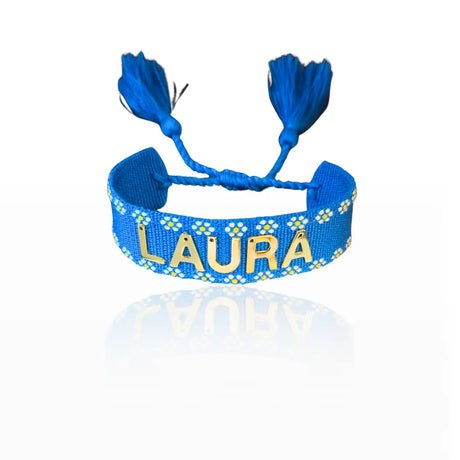 bracciale in filo blu con bordi con fiori bianchi, con nappa regolabile, personalizzato con nome in acciaio inox colore oro. Regalo personalizzato unisex per ogni occasione, anche per auto regalo