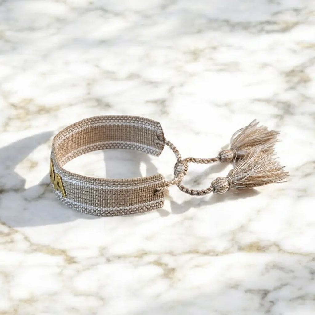 bracciale in filo colore crema con bordi bianchi personalizzato con nome in acciaio inox colore oro, idea regalo personalizzato per donna, chiusura regolabile con nappa