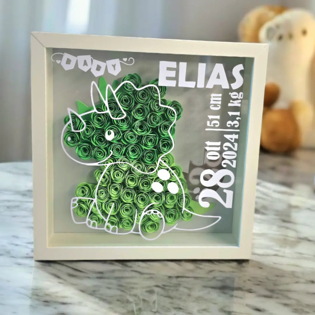 Shadow Box cornice bianca con dinosauro verde di carta fiori 3d, personalizzato con nome del bimbo e dati alla nascita. Regalo elegante per neomamma e bimbo.